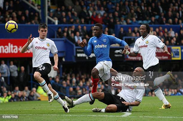Aruna Dindane of Portsmouth has his run on goal cut off by Clarke Carlisle of Burnley during the Barclays Premier League match between Portsmouth and...