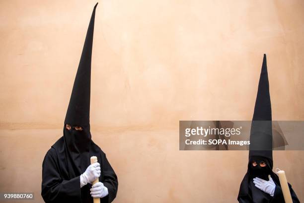 Penitents of "La Concepcion" brotherhood wait during the Holy Thursday procession through an Albaicín neighbourhood street. Every year thousands of...