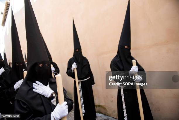 Penitents of "La Concepcion" brotherhood wait during the Holy Thursday procession through an Albaicín neighbourhood street. Every year thousands of...