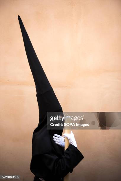 Penitent from "La Concepcion" brotherhood waits during the Holy Thursday procession in an Albaicín neighbourhood street. Every year thousands of...