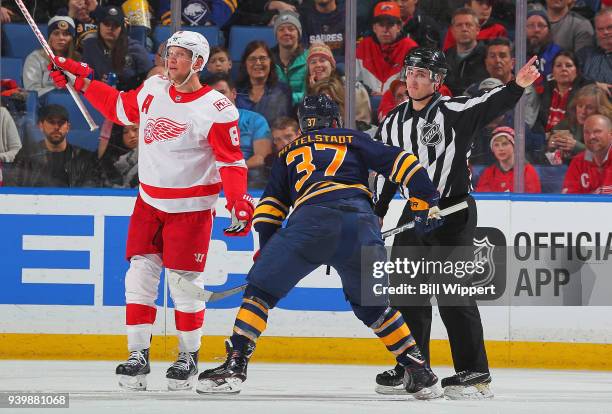 Casey Mittelstadt of the Buffalo Sabres receives a minor penalty during his first NHL game for a face-off violation from linesman James Tobias during...