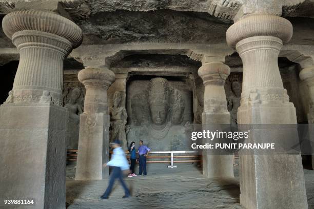 This photo taken on March 9, 2018 shows tourists visiting temple caves on Elephanta Island near Mumbai. Hundreds of villagers on the UNESCO...