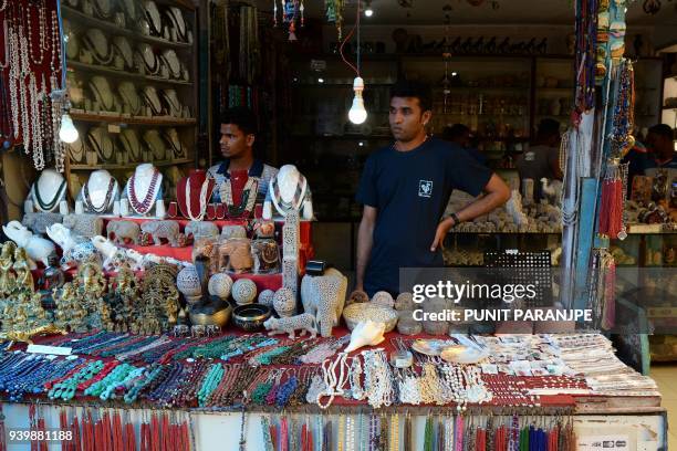 This photo taken on March 9, 2018 shows a shopkeeper waiting for tourists on Elephanta Island near Mumbai. Hundreds of villagers on the UNESCO...