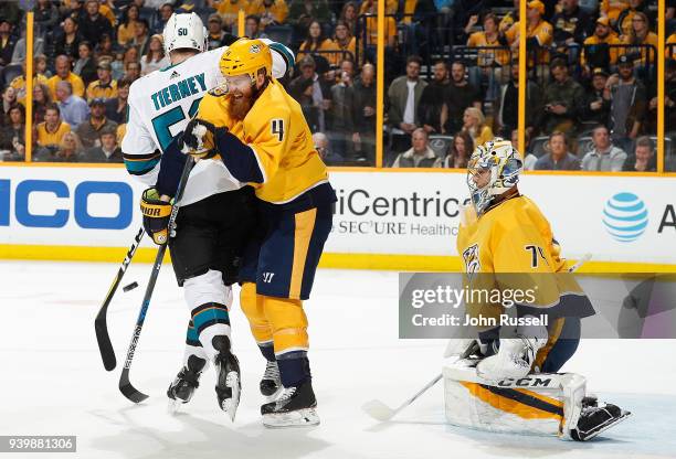 Ryan Ellis battles against Chris Tierney of the San Jose Sharks in front of goalie Juuse Saros during an NHL game at Bridgestone Arena on March 29,...