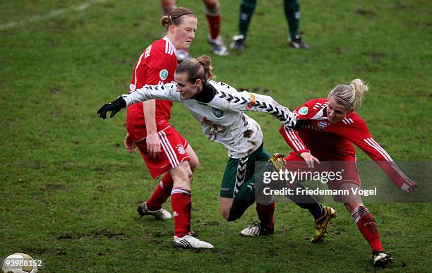 Melanie Behringer and Julia Simic of Bayern battle for the ball with Simone Laudehr of Duisburg during the Women's Bundesliga match between FCR 2001...