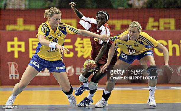 Sweden's Johanna Wiberg and Johanna Ahlm vie for the ball against Congo during their first round match at the 2009 World Women's Handball...