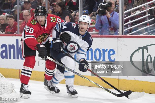 Brandon Saad of the Chicago Blackhawks and Josh Morrissey of the Winnipeg Jets watch for the puck in the first period at the United Center on March...