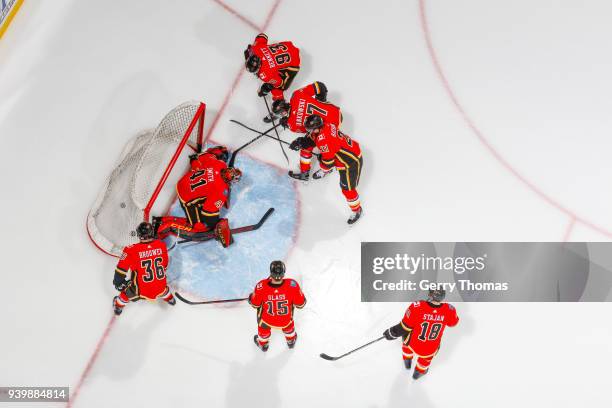 Players of the Calgary Flames put Goalie Mike Smith under pressure at warm up in an NHL game on March 29, 2018 at the Scotiabank Saddledome in...