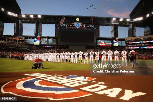 The Arizona Diamondbacks stand attended for the national anthem prior to the openning day MLB game against the Colorado Rockies at Chase Field on...