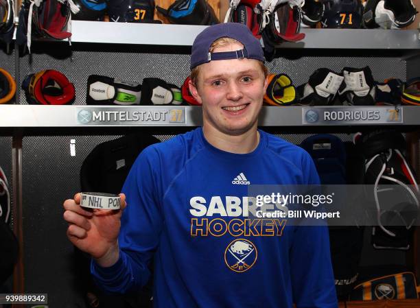 Casey Mittelstadt of the Buffalo Sabres holds the puck from his first NHL point from an assist in his first NHL game against the Detroit Red Wings on...