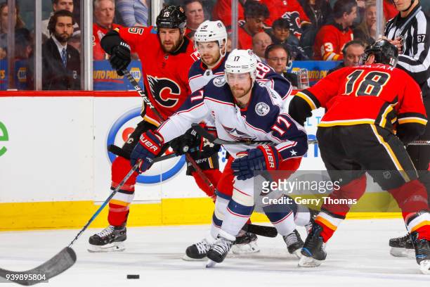 Tanner Glass, Matt Stajan of the Calgary Flames and Oliver Bjorkstrand and Brandon Dubinsky of the Columbus Blue Jackets battle for the puck in an...