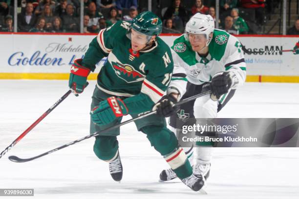 John Klingberg of the Dallas Stars hooks Zach Parise of the Minnesota Wild during the game at the Xcel Energy Center on March 29, 2018 in St. Paul,...