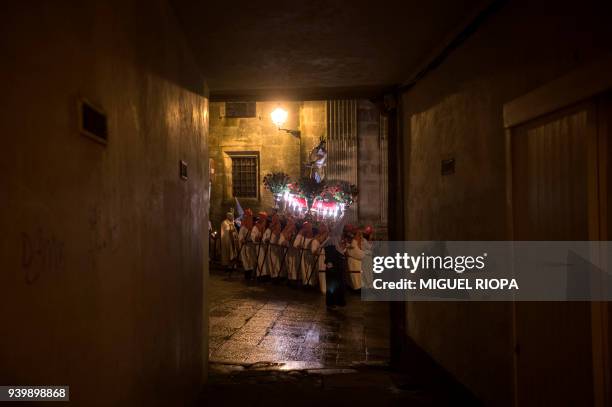 Penitents of the "Our Whipped Jesus Father" brotherhood carry the figure of "Whipped Jesus" during a procession in Santiago de Compostela,...