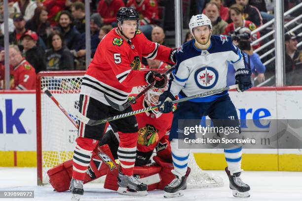 Chicago Blackhawks defenseman Connor Murphy pushes Winnipeg Jets right wing Joel Armia as they stand in front of Chicago Blackhawks goalie Collin...