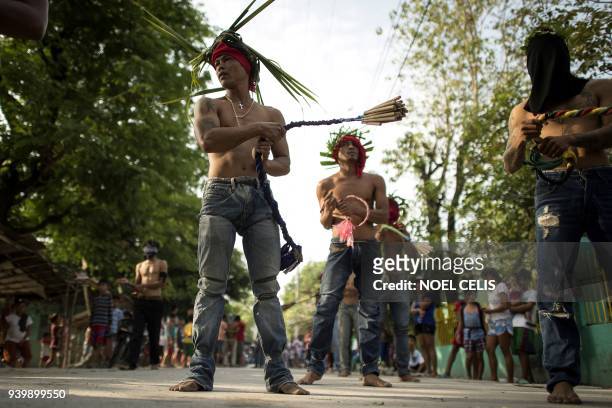 Flagellant RJ Rivera whips his back with bamboo before being wounded to bleed as part of his penitence during the re-enactment of the crucifixion of...