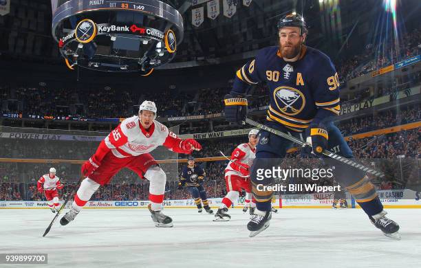 Ryan O'Reilly of the Buffalo Sabres skates for the puck against Danny DeKeyser of the Detroit Red Wings during an NHL game on March 29, 2018 at...