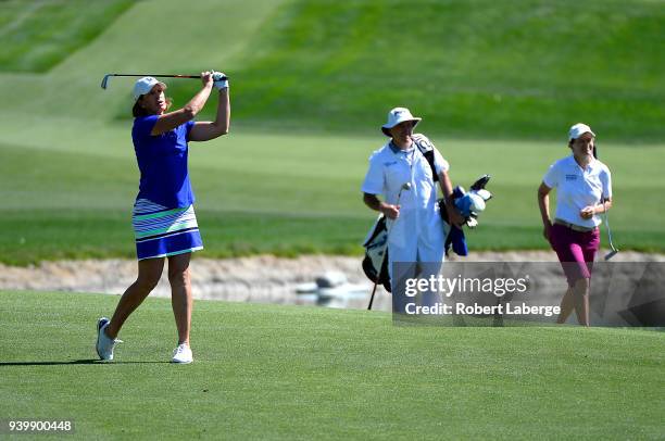 Juli Inkster makes an approach shot as Catriona Matthew of Scotland and her caddie look on during round one of the ANA Inspiration on the Dinah Shore...