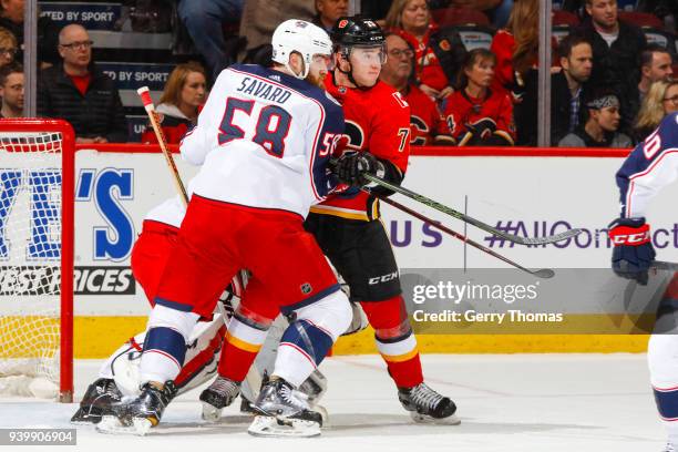 David Savard of the Columbus Blue Jackets and Micheal Ferland of the Calgary Flames battle for position in an NHL game on March 29, 2018 at the...