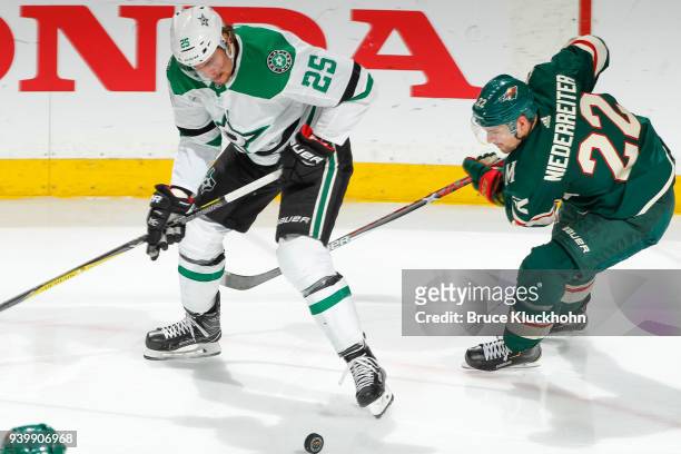 Brett Ritchie of the Dallas Stars and Nino Niederreiter of the Minnesota Wild battle for the puck during the game at the Xcel Energy Center on March...
