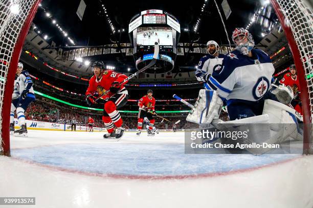 Andreas Martinsen of the Chicago Blackhawks skates past goalie Eric Comrie of the Winnipeg Jets in the third period at the United Center on March 29,...