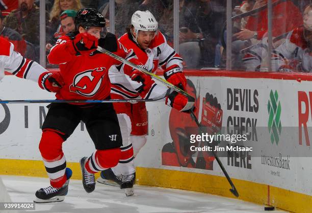Blake Coleman of the New Jersey Devils in action against Justin Williams of the Carolina Hurricanes on March 27, 2018 at Prudential Center in Newark,...