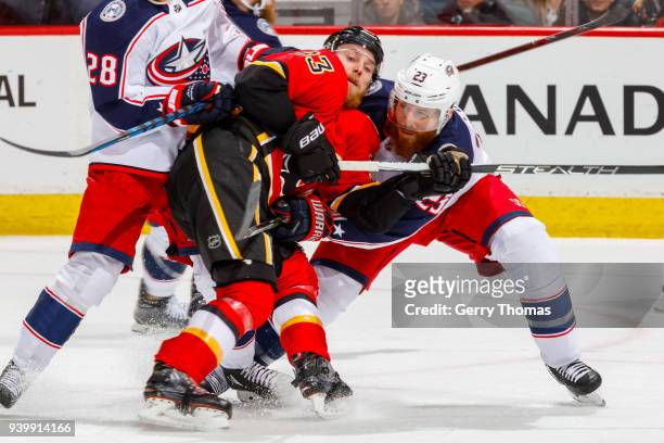 Sam Bennett of the Calgary Flames and Ian Cole of the Columbus Blue Jackets battle for position in an NHL game on March 29, 2018 at the Scotiabank...