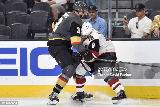 Brayden McNabb of the Vegas Golden Knights and Clayton Keller of the Arizona Coyotes battle for the puck during the game at T-Mobile Arena on March...