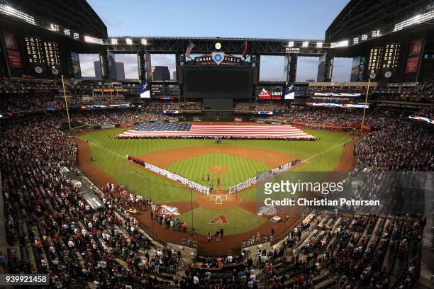 The Arizona Diamondbacks and the Colorado Rockies stand attended for the national anthem before the opening day MLB game at Chase Field on March 29,...