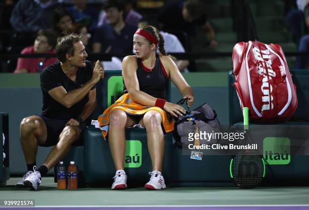 Jelena Ostapenko of Latvia speaks with her coach David Taylor in the change over against Danielle Collins of the United States in their semifinal...