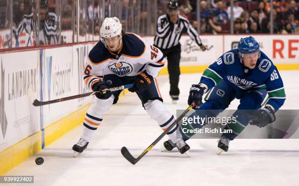 Pontus Aberg of the Edmonton Oilers tries to break free from Jussi Jokinen of the Vancouver Canucks in NHL action on March 2018 at Rogers Arena in...