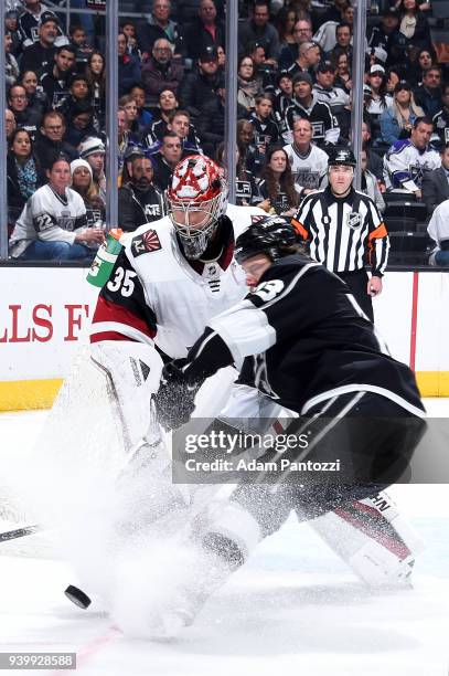 Darcy Kuemper of the Arizona Coyotes battles for the puck against Kyle Clifford of the Los Angeles Kings during the game on March 29, 2018 at Staples...