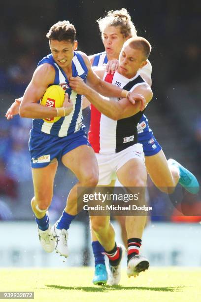 Sebastian Ross of the Saints tackles Ben Jacobs of the Kangaroos during the round two AFL match between the North Melbourne Kangaroos and the St...