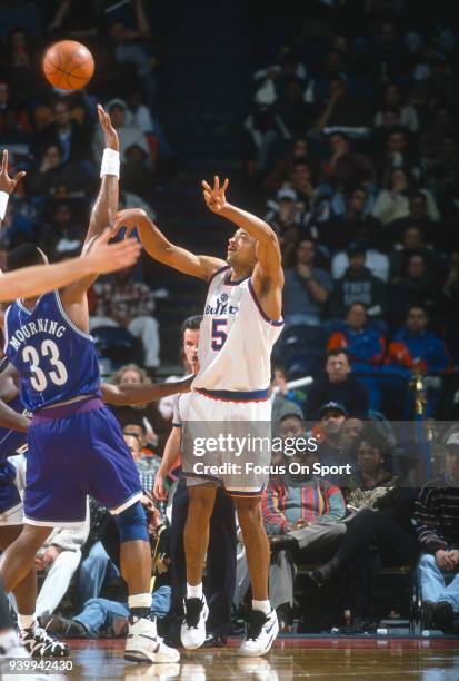 Juwan Howard of the Washington Bullets shoots over Alonzo Mourning of the Charlotte Hornets during an NBA basketball game circa 1995 at the US...