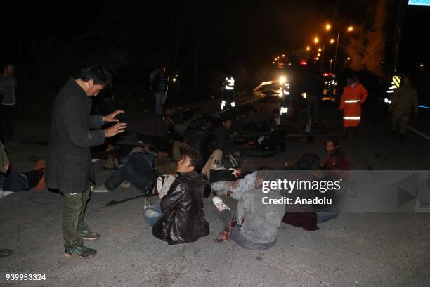 Injured migrants are seen after a minibus, carrying migrants, crashed into a light pole and caught fire in Igdir, Turkey on March 30, 2018. Seventeen...