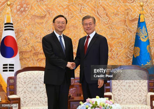 South Korean President Moon Jae-In shakes hands with Chinese state councilor Yang Jiechi at the Presidential blue house on March 30, 2018 in Seoul,...