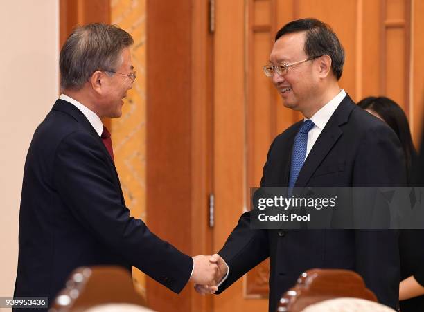 South Korean President Moon Jae-In shakes hands with Chinese state councilor Yang Jiechi at the Presidential blue house on March 30, 2018 in Seoul,...