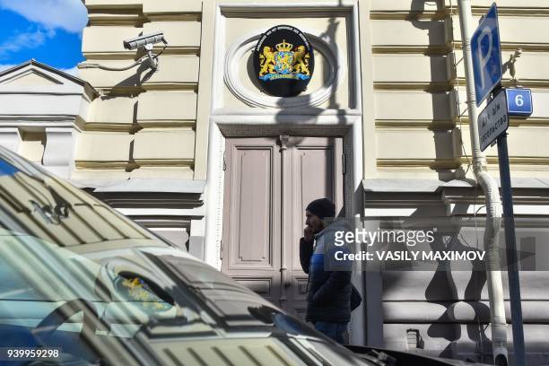 Picture taken on March 29, 2018 shows a man walking past the embassy of the Netherlands in Moscow. Russia on March 29, 2018 announced a mass...