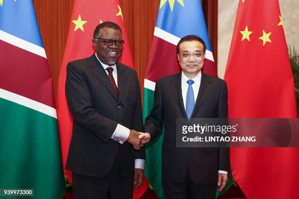 Chinese Premier Li Keqiang shakes hands with Namibia's President Hage Geingob at the Great Hall of People in Beijing on March 30, 2018.