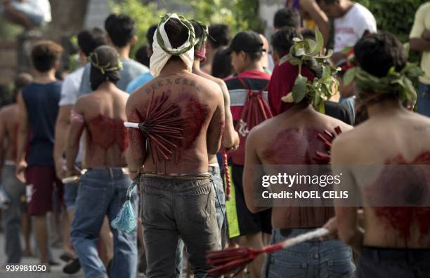 Participants whip their bloodied backs with bamboo as part of their penitence during the re-enactment of the crucifixion of Jesus Christ for Good...