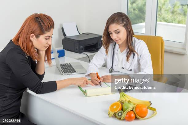 nutritionist showing diet plan - nutritionist stock pictures, royalty-free photos & images