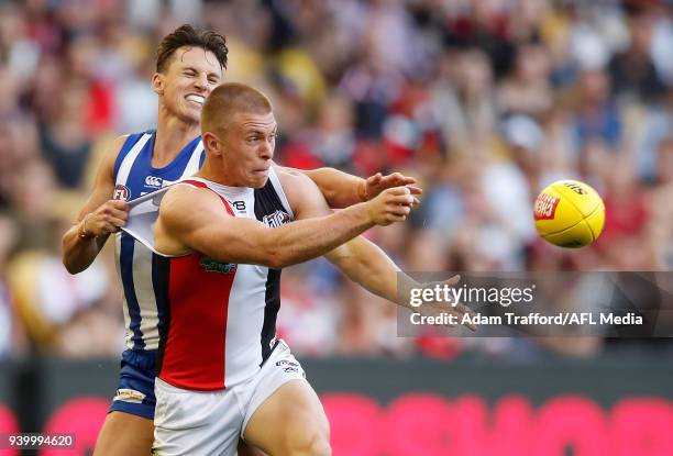 Sebastian Ross of the Saints handpasses the ball ahead of Ben Jacobs of the Kangaroos during the 2018 AFL round 02 Good Friday Kick for the Kids...