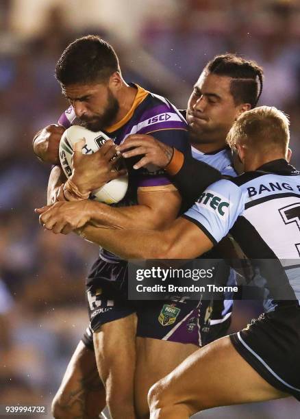 Jesse Bromwich of the Storm is tackled by the Sharks defence during the round four NRL match between the Cronulla Sharks and the Melbourne Storm at...