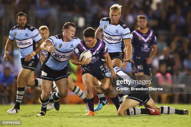 Brodie Croft of the Storm is tackled by the Sharks defence during the round four NRL match between the Cronulla Sharks and the Melbourne Storm at...