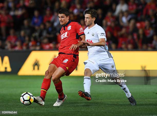 George Blackwood of Adelaide United passes in front of Matthew Ridenton of Wellington Phoenix during the round 25 A-League match between Adelaide...