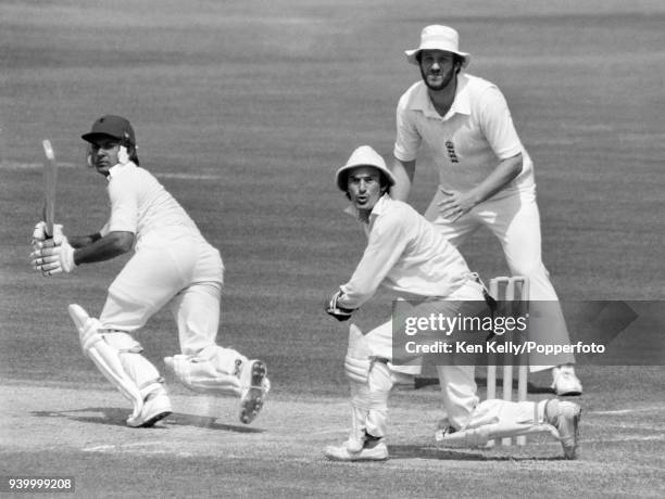 England wicketkeeper Alan Knott and captain Ian Botham follow the ball after a shot played by West Indies batsman Faoud Bacchus during the 4th Test...