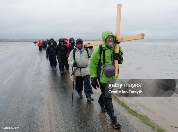 Pilgrims celebrate Easter by crossing over the tidal causeway carrying wooden crosses on the final leg of their annual pilgrimage to the Holy Island...