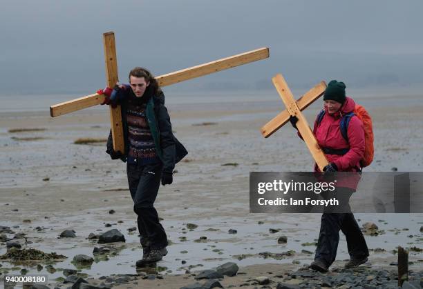 Pilgrims celebrate Easter by crossing over the tidal causeway carrying wooden crosses on the final leg of their annual pilgrimage to the Holy Island...