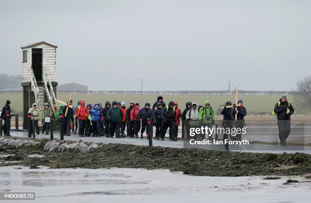 Pilgrims celebrate Easter by crossing over the tidal causeway carrying wooden crosses on the final leg of their annual pilgrimage to the Holy Island...