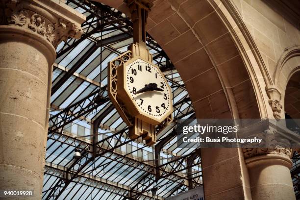 art deco clock hanging from arch at gare du nord station in paris, france - treinstation stockfoto's en -beelden
