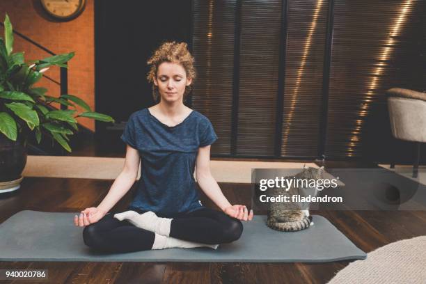 practicing yoga at home - lotus position imagens e fotografias de stock